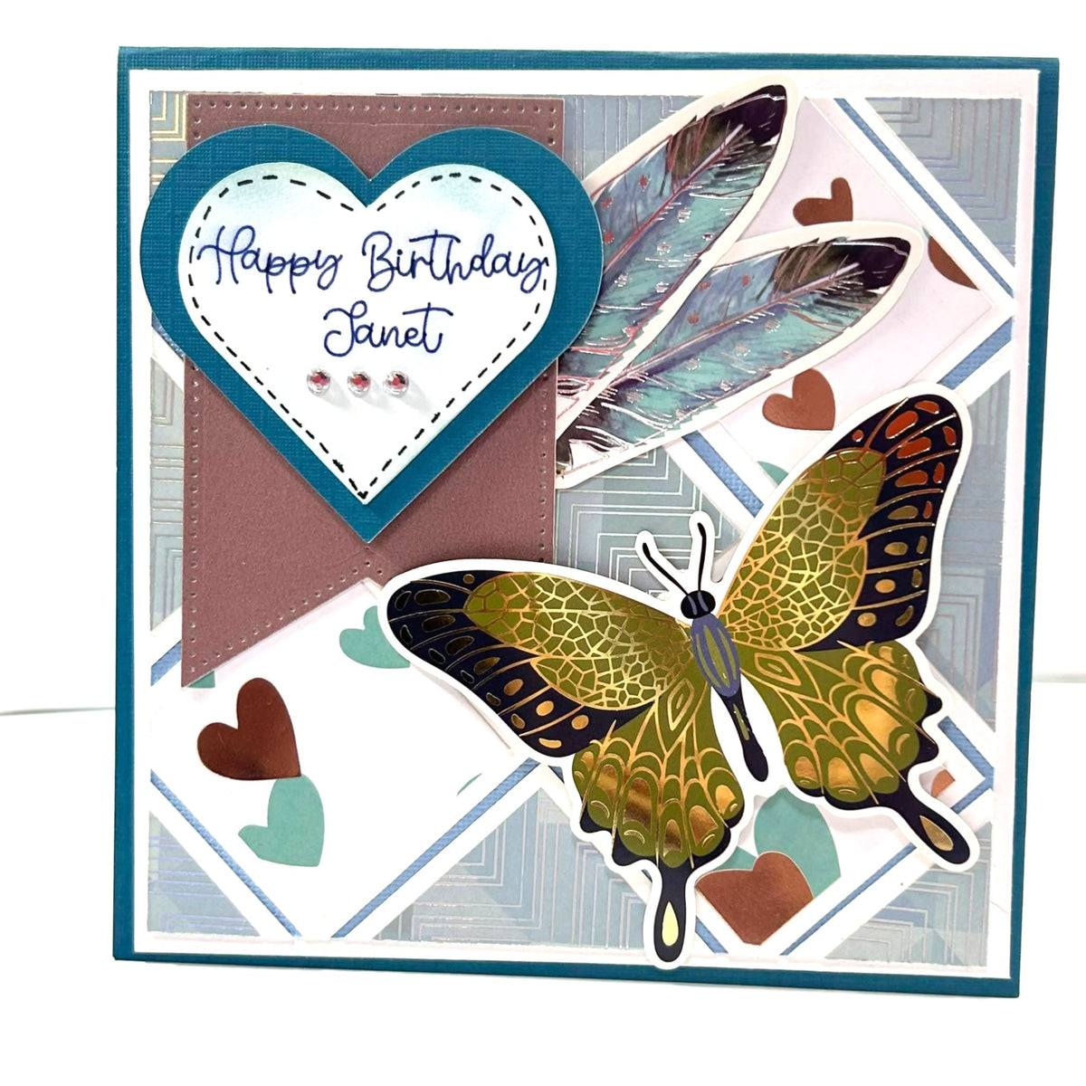 square greeting card, blue background, monarch butterfly in lower right corner and blue and white heart in top left